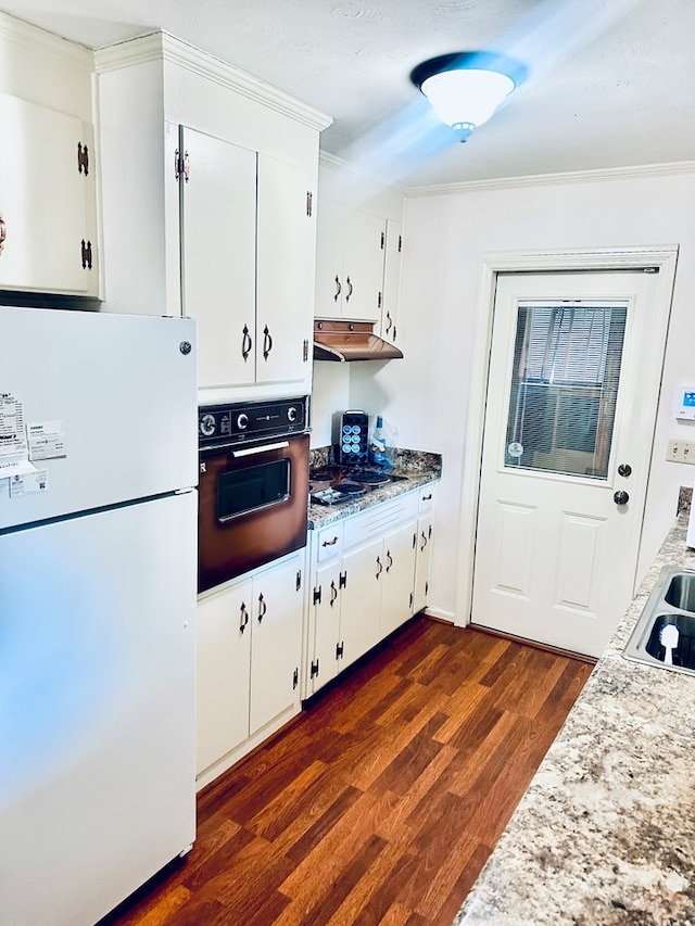 kitchen with dark wood-style flooring, wall oven, freestanding refrigerator, under cabinet range hood, and white cabinetry