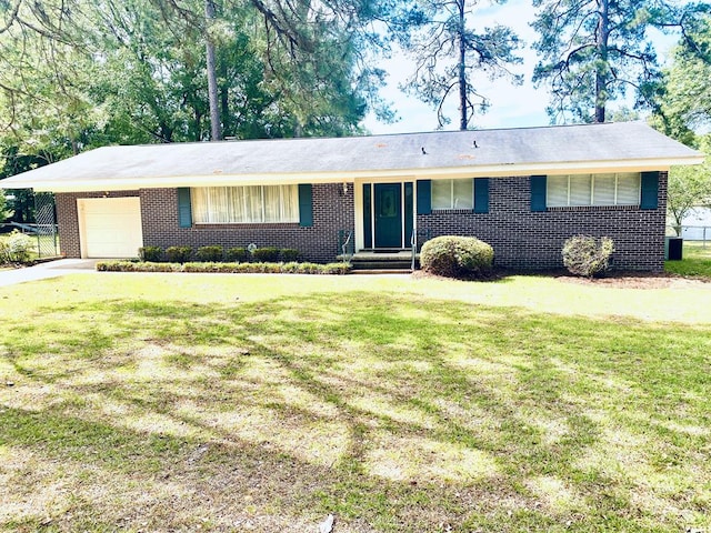 ranch-style home featuring brick siding, a front lawn, an attached garage, and driveway