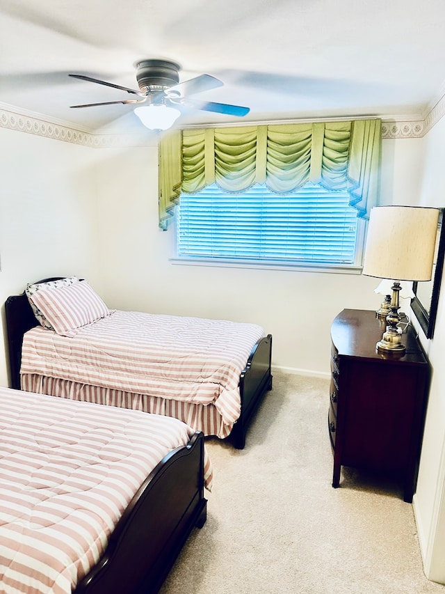 carpeted bedroom featuring baseboards and a ceiling fan