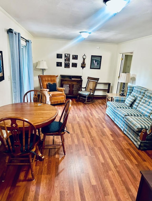 dining area with ornamental molding and wood finished floors