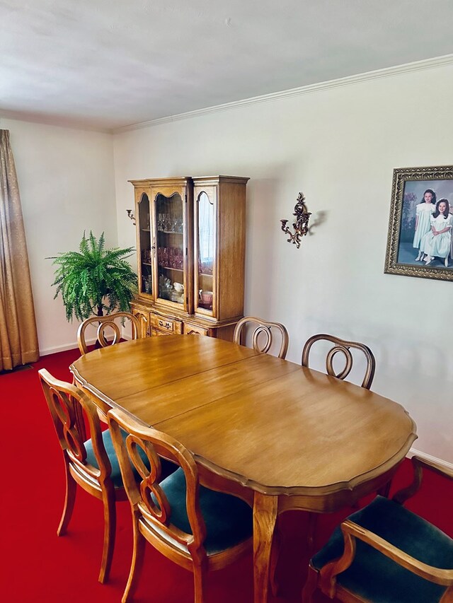 dining space featuring crown molding and baseboards