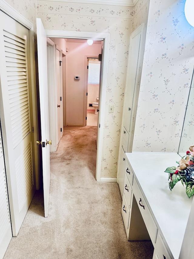 hallway featuring light carpet and wallpapered walls