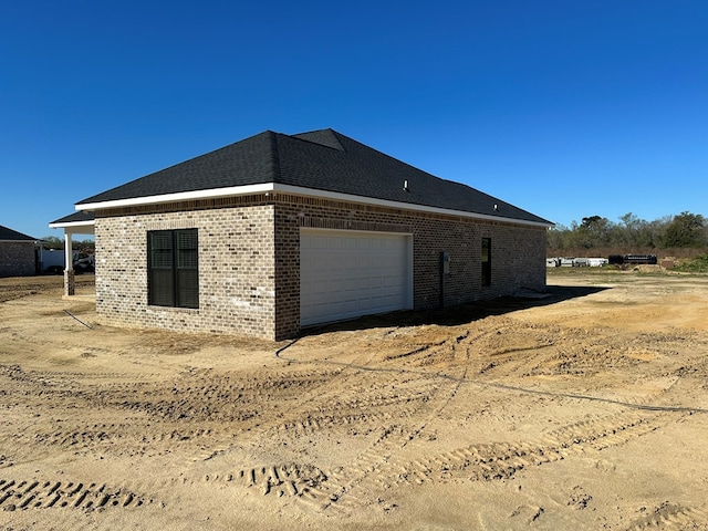 view of property exterior with a garage and brick siding