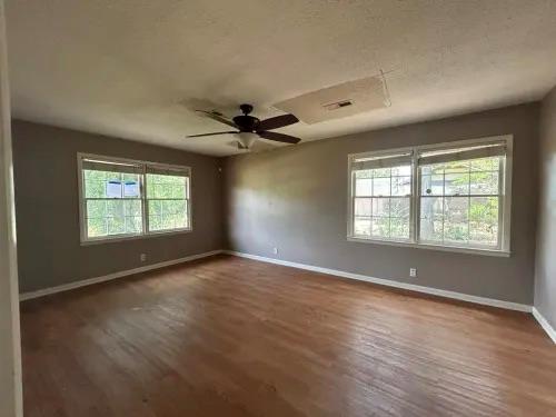 empty room with ceiling fan and dark hardwood / wood-style floors