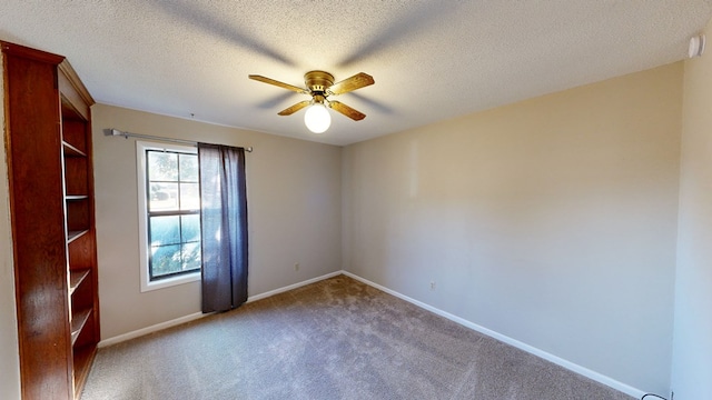 spare room featuring light carpet, a textured ceiling, and ceiling fan