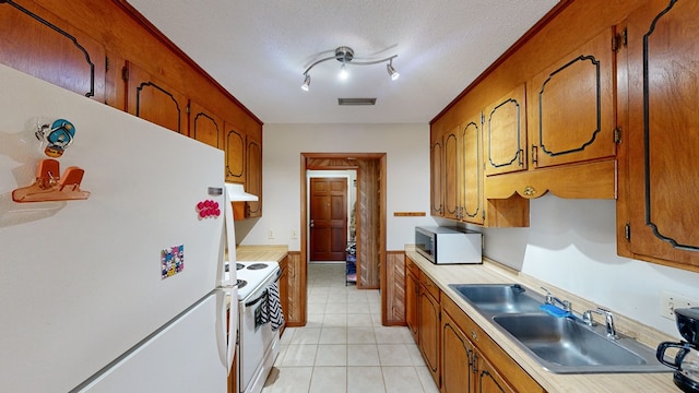 kitchen featuring a textured ceiling, white appliances, and sink