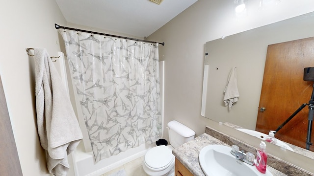 full bathroom with tile patterned floors, vanity, toilet, and shower / bath combo with shower curtain