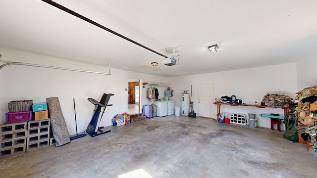 garage with washing machine and clothes dryer, a garage door opener, and water heater