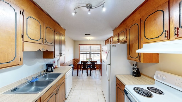 kitchen with a textured ceiling, sink, and white appliances