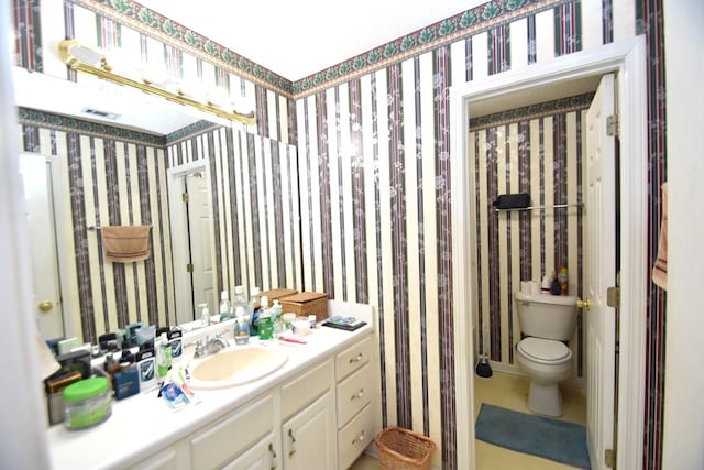 2023 Brackin Dr, Dothan, AL 36301 - bathroom featuring toilet, vanity, tile patterned flooring, and wallpapered walls