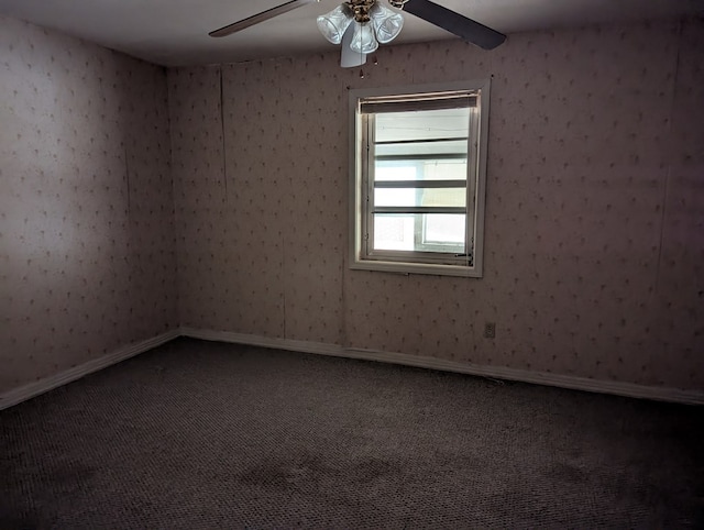 carpeted spare room featuring ceiling fan