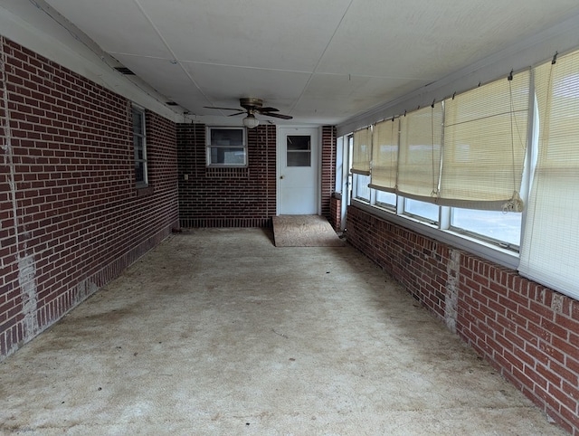 unfurnished sunroom featuring ceiling fan