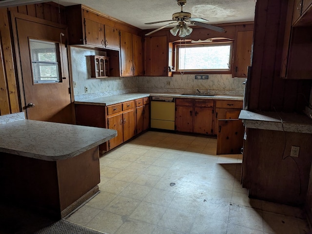 kitchen with tasteful backsplash, dishwasher, sink, ceiling fan, and a textured ceiling