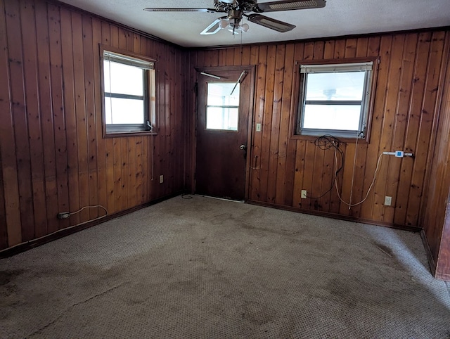 carpeted empty room with plenty of natural light, a textured ceiling, and ceiling fan