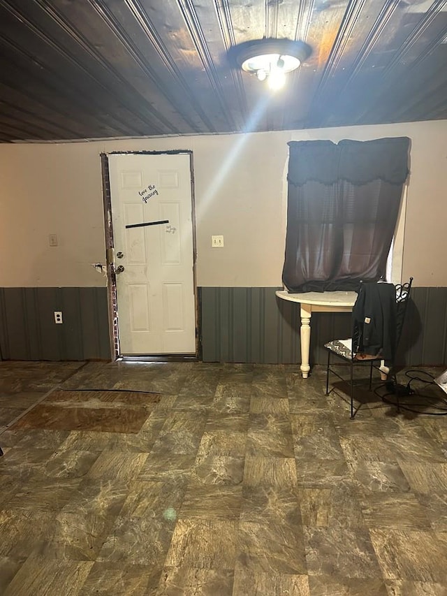 foyer entrance featuring wood walls and vaulted ceiling