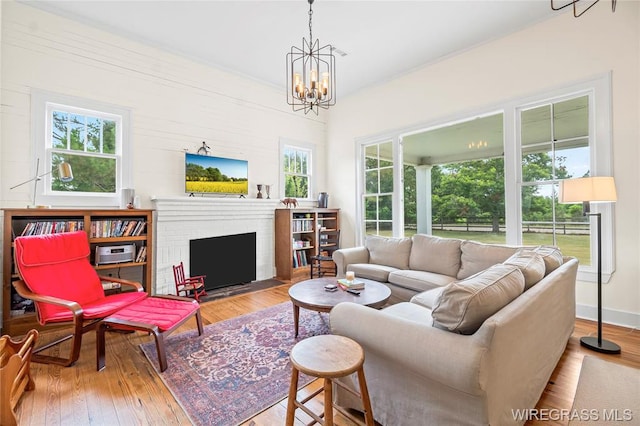5606 Rocky Creek Rd, Ashford, AL 36312 - living room with wood finished floors, a chandelier, and a fireplace