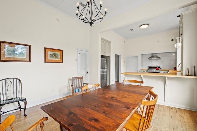 5606 Rocky Creek Rd, Ashford, AL 36312 - dining space featuring a chandelier, light wood finished floors, crown molding, and a towering ceiling