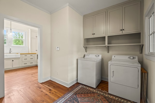 5606 Rocky Creek Rd, Ashford, AL 36312 - laundry area with separate washer and dryer, light wood-style flooring, ornamental molding, and cabinet space