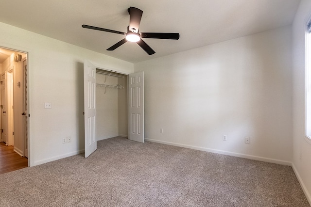 unfurnished bedroom with light carpet, ceiling fan, a closet, and baseboards