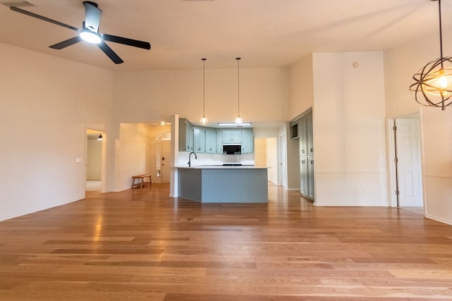 kitchen with a ceiling fan, light countertops, blue cabinetry, and wood finished floors