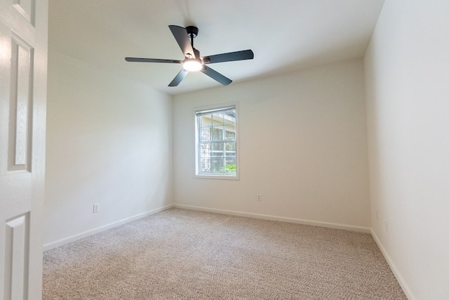 spare room with light carpet, baseboards, and a ceiling fan