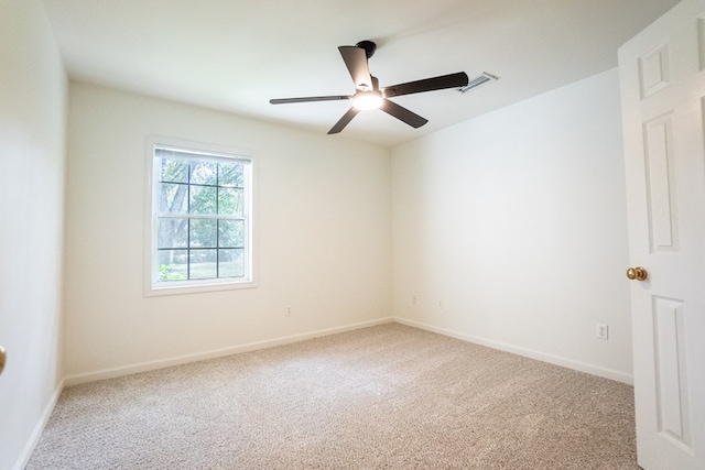 spare room with carpet floors, visible vents, baseboards, and a ceiling fan