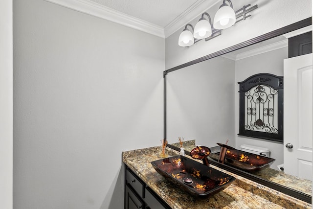 bathroom featuring toilet, ornamental molding, and vanity