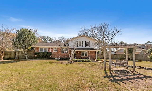 rear view of property featuring fence, brick siding, a lawn, and a pergola