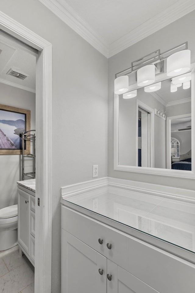 bathroom featuring visible vents, toilet, marble finish floor, ornamental molding, and vanity