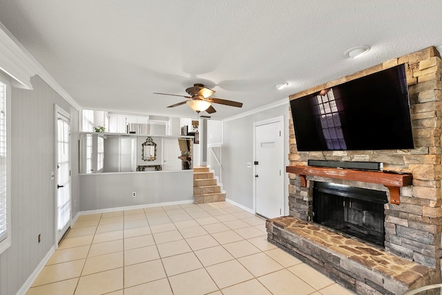 living room with stairs, ornamental molding, light tile patterned floors, a fireplace, and a textured ceiling