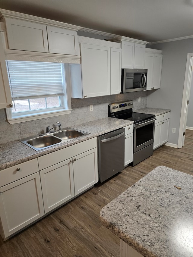 kitchen featuring decorative backsplash, stainless steel appliances, white cabinets, and sink