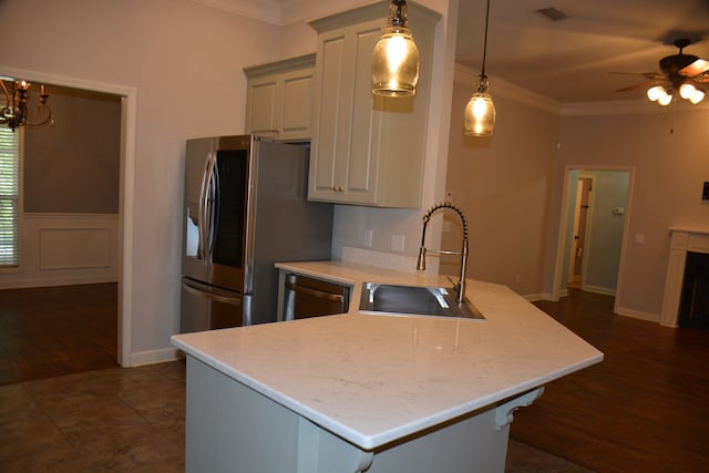 kitchen with a peninsula, crown molding, stainless steel appliances, and a sink
