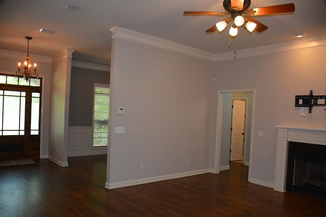 unfurnished living room with dark wood-type flooring, a fireplace, ornamental molding, and ceiling fan with notable chandelier