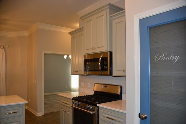 kitchen featuring dark tile patterned flooring, stainless steel appliances, light countertops, ornamental molding, and gray cabinetry