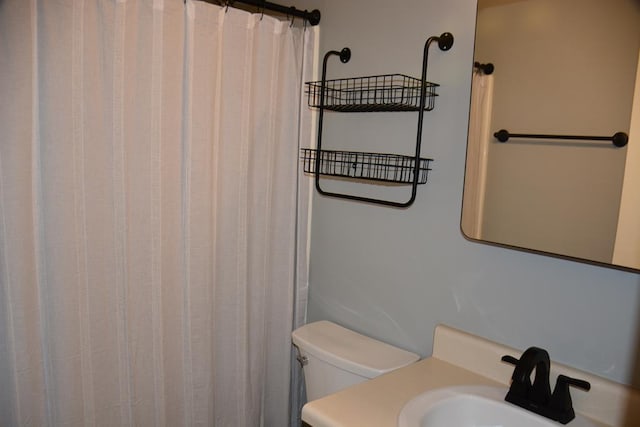 full bathroom with toilet, a shower with curtain, and a sink