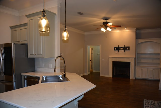 kitchen featuring a peninsula, a sink, ceiling fan, and crown molding