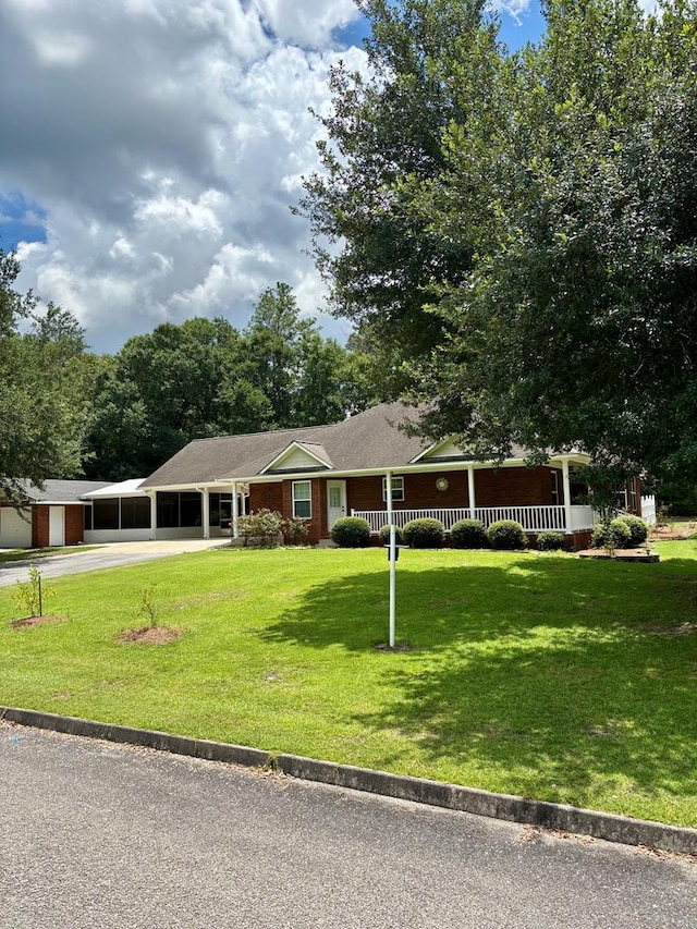 252 Red Maple Dr, Flomaton, AL 36441 - ranch-style house with concrete driveway, a front yard, and covered porch