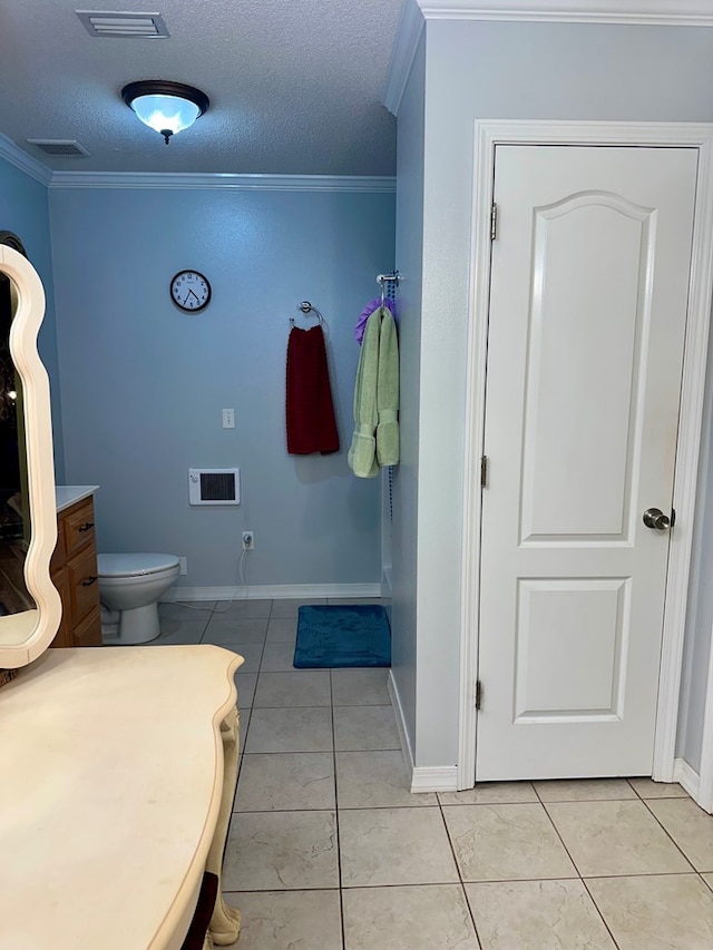 bathroom featuring tile patterned flooring, ornamental molding, a textured ceiling, and visible vents