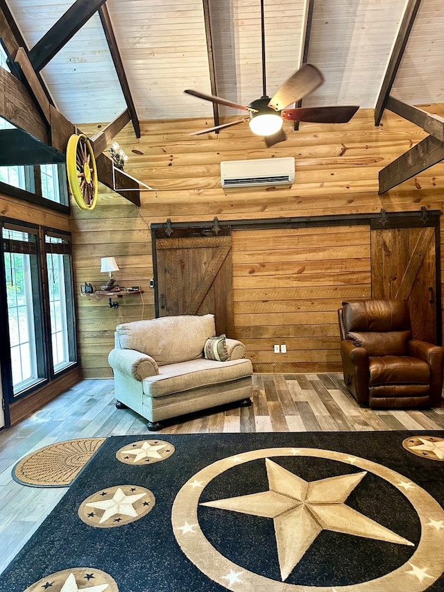 living room featuring an AC wall unit, a barn door, wooden walls, and high vaulted ceiling