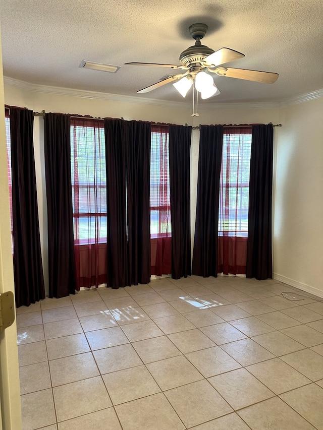 unfurnished room with crown molding, a textured ceiling, and light tile patterned floors
