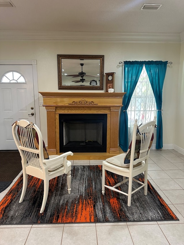 living area with a glass covered fireplace, plenty of natural light, and tile patterned flooring