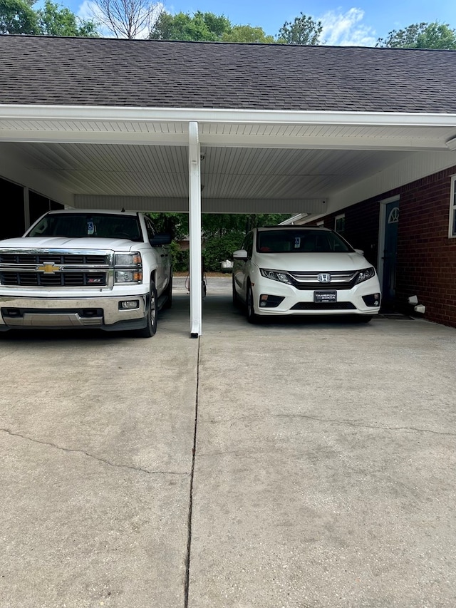 view of parking featuring driveway and an attached carport