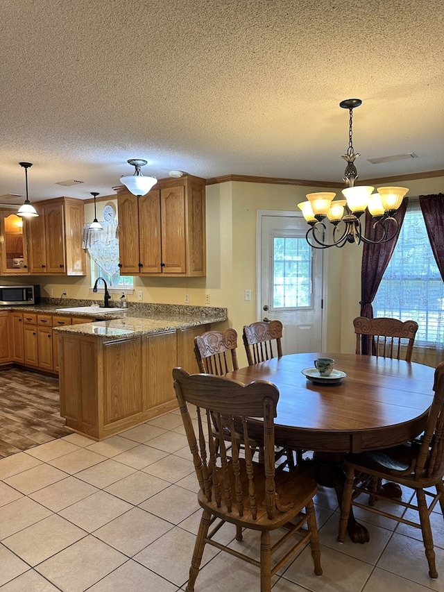 dining room with an inviting chandelier, light tile patterned flooring, and a textured ceiling