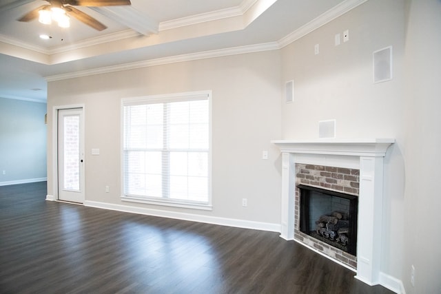 unfurnished living room featuring a brick fireplace, ornamental molding, dark hardwood / wood-style floors, and a healthy amount of sunlight