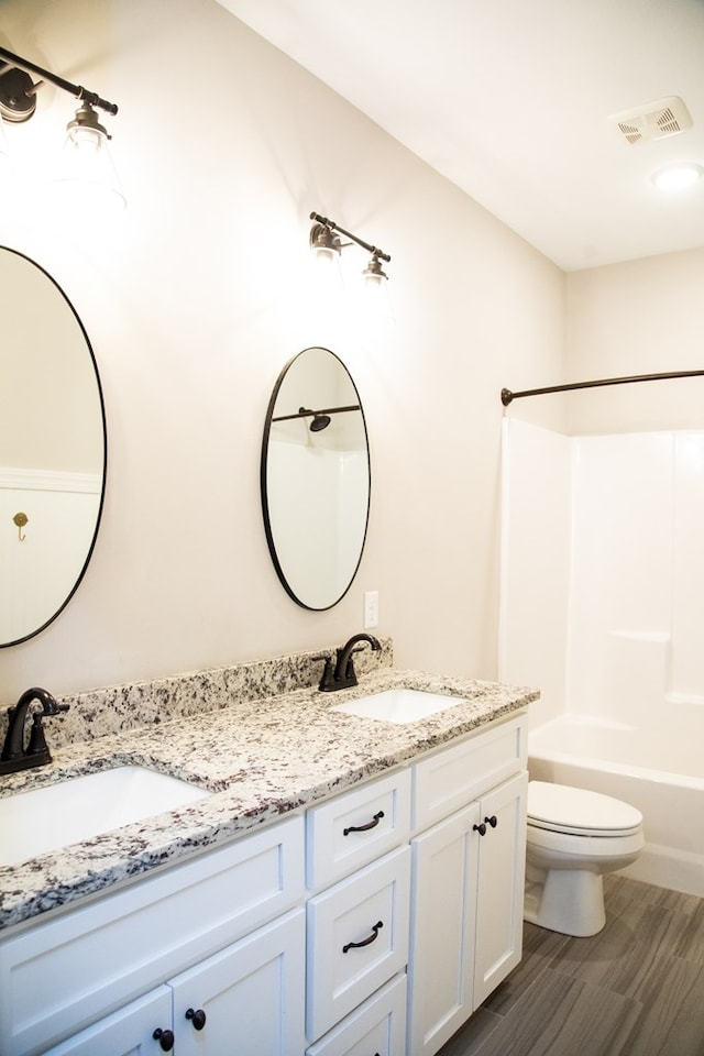 full bathroom with toilet, wood-type flooring, shower / washtub combination, and vanity