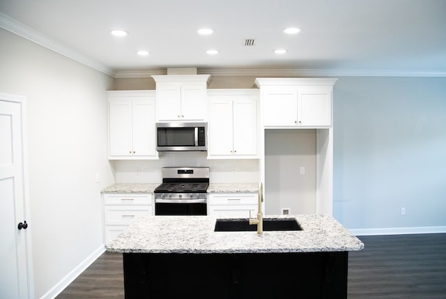 kitchen featuring appliances with stainless steel finishes, white cabinetry, an island with sink, dark hardwood / wood-style flooring, and light stone countertops