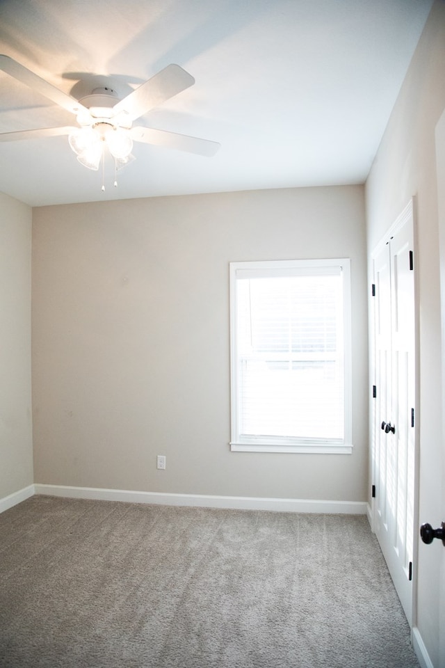 unfurnished room with ceiling fan and light colored carpet