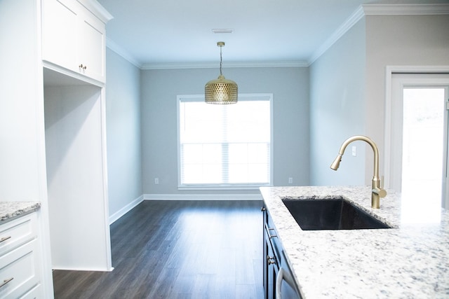 kitchen featuring pendant lighting, sink, ornamental molding, light stone countertops, and white cabinets