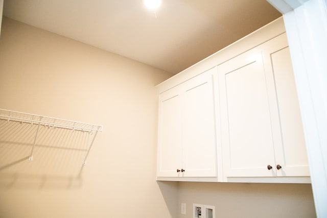 laundry room with hookup for a washing machine and cabinets