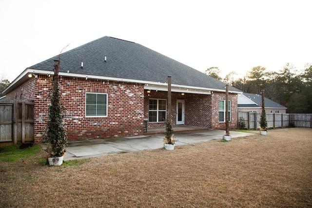 back of property with a lawn and a patio area